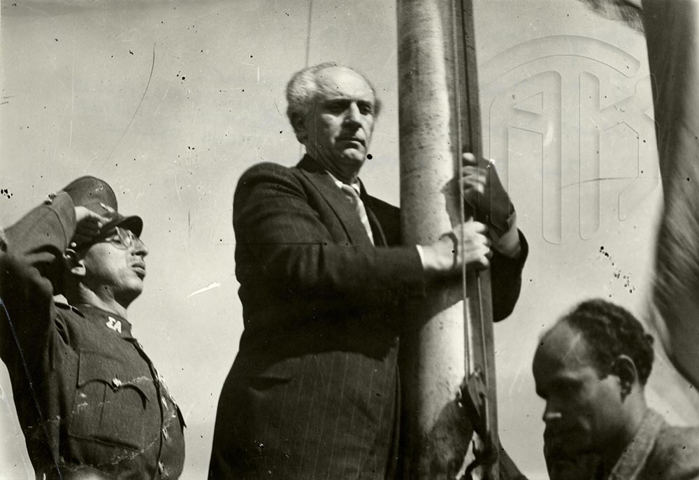 18 Οκτωβρίου 1944. Ο πρωθυπουργός Γεώργιος Παπανδρέου κατά την πρώτη ελεύθερη έπαρση της ελληνικής σημαίας στην Ακρόπολη, Γενικά Αρχεία του Κράτους – Κεντρική Υπηρεσία –  Βασίλης Τσακιράκης